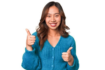 A young chinese woman raising both thumbs up, smiling and confident.