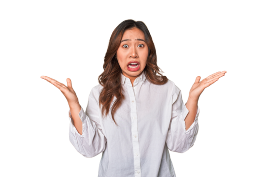 A young chinese woman screaming to the sky, looking up, frustrated.