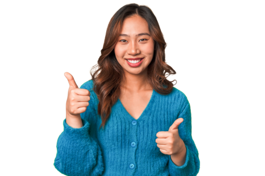 A young chinese woman raising both thumbs up, smiling and confident.