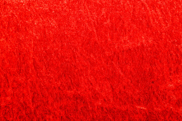 Texture of red velor corduroy fabric with folds.