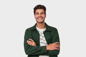 Young handsome caucasian man isolated on white background who feels confident, crossing arms with determination.