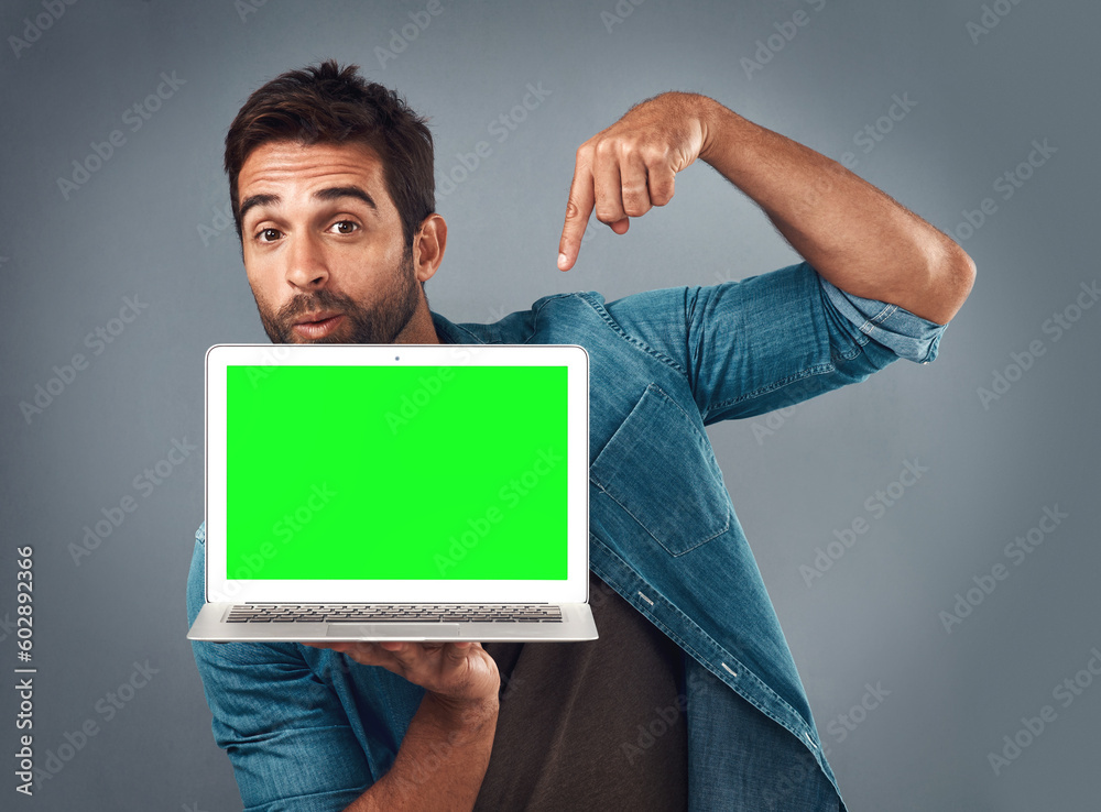 Poster man, laptop and pointing on mockup green screen for advertising or marketing against a grey studio b