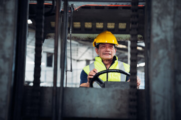 Portrait of industrial worker driving a forklift in the factory. Engineer is working and maintaining in the warehouse.