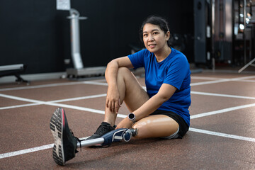Fototapeta na wymiar Happy Asia woman with prosthetic leg exercise at gym or fitness 