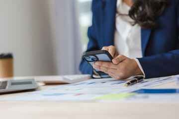 Close-up of asian businesswoman using calculator and laptop for mathematical finance on wooden table, tax, accounting, statistics and analytical research concept