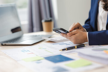 Close-up of asian businesswoman using calculator and laptop for mathematical finance on wooden table, tax, accounting, statistics and analytical research concept