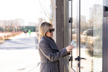 Smart home concept - close up of woman use mobile phone to open electronic lock