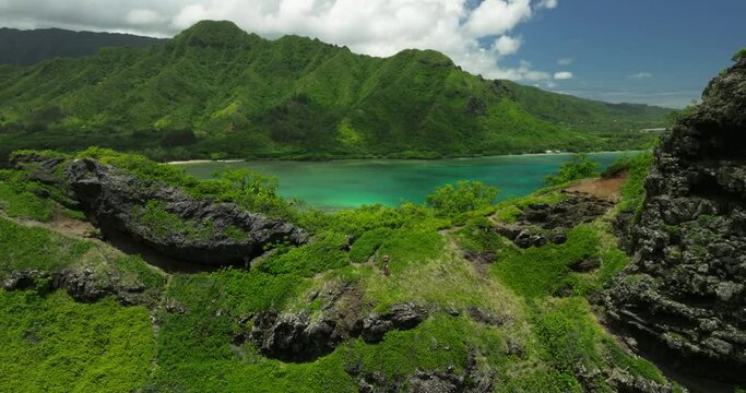 Woman hiking on a ridge of a mountain in tropical paradise 