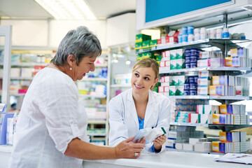 Pharmacist explaining medicine to a woman in the pharmacy for pharmaceutical healthcare prescription. Medical, counter and female chemist talking to a patient about medication in a clinic dispensary - obrazy, fototapety, plakaty