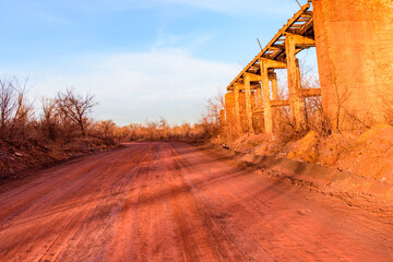 Obraz premium Red dirt road polluted with the iron ore. Environmental pollution