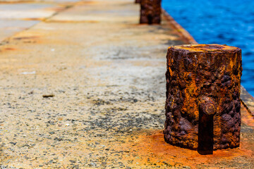 Old rusty mooring bollard at pier