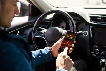 Man use mobile phone in the car, betting on sports