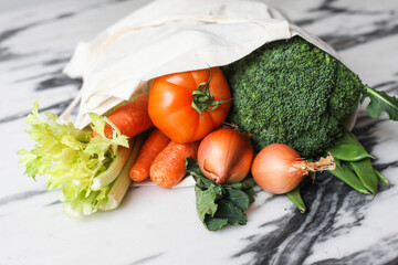 Vegetables grocery in an eco bag, in a marble table