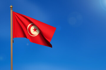 Tunisia. Flag blown by the wind with blue sky in the background.