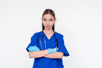 A joyful and smiling medical student or nurse or intern posing with her arms folded while wearing gloves. Isolated on a white background.