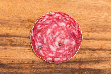 Slice of salami on wooden board