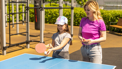Happy Mother and Daughter Learning to Play Ping Pong Sport Cheerful family playing leisure sports...