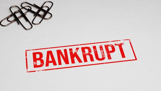 Putting red BANKRUPT rubber stamp on paper with paper pins in the background. 4k 3D animation