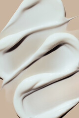 cosmetic smears of creamy texture on a beige background