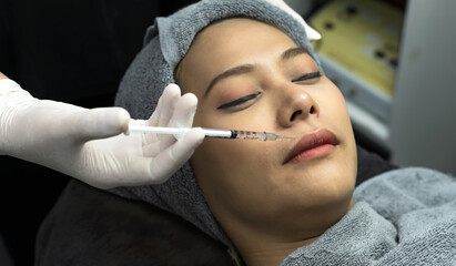 Close up beautician hand injecting filler into woman face, Beauty Clinic