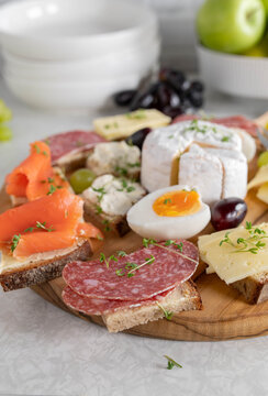 Platter with cold cuts sandwiches. Topped with smoked salmon, cheese, salami and boild eggs