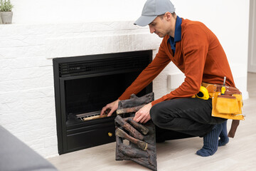 Professional technician installing electric fireplace in room.