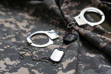 military camouflage uniform, handcuffed on background.