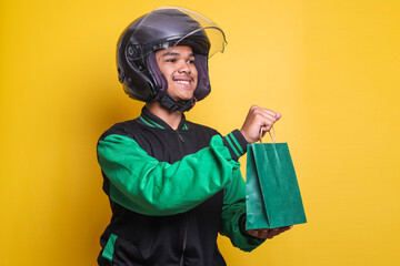 Asian online taxi driver motorbike wearing green jacket and helmet smiling while giving green paper...