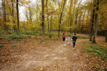 Obraz premium Mother with kids on a walk in autumn forest.