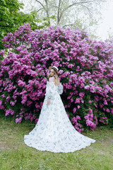 Beautiful, stylish, cute blonde in a white dress with a green pattern as a model for a photo shoot...