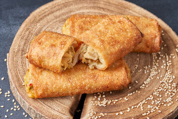 Fried spring rolls on a wooden kitchen board.