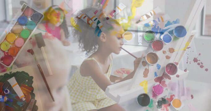 Animation of art equipment over happy diverse schoolgirls painting in art class