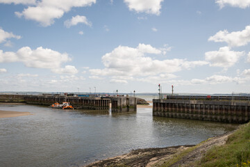 Fototapeta na wymiar breakwater in low tide at burry Port in South Wales. British seaside town built on shipping tin and steel during industrial period on sunny summer day