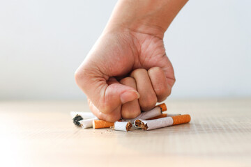 Hand fist smash or punch on cigarette. Smoking reduction campaign in World No Tobacco Day.