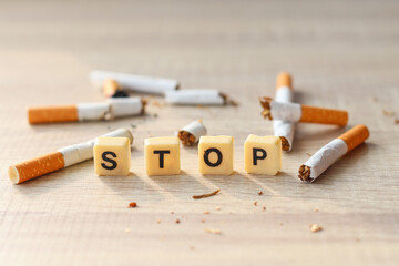 Broken cigarettes with word Stop on wooden background. Stop smoking, no tobacco day concept.