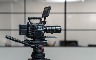 Professional cinema camera on tripod in a trendy loft studio for movie production