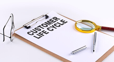 CUSTOMER LIFE CYCLE text on clipboard on white background, business concept