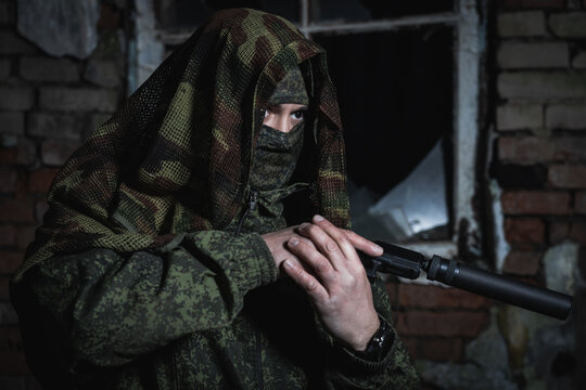 Special forces soldier with a pistol with a silencer in his hands at war in a dark house.