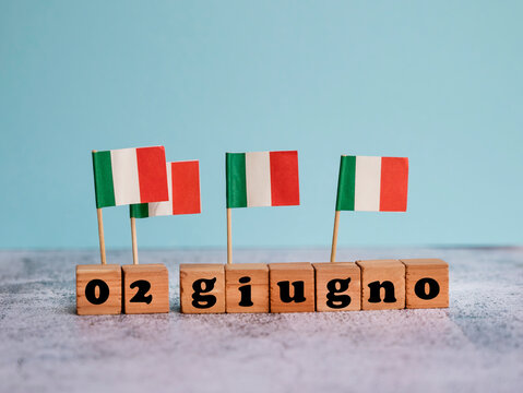 Wooden cubes and miniature Italy flags with the date 2nd June .National day ,Republic day 