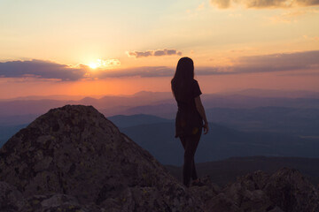 Woman Silhouette in the Mountain on Orange Sunset Cloudy Sky Background .Orange Sunset in Vitosha Mountain ,Bulgaria 