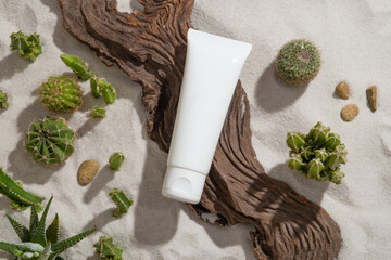 Fresh summer concept with a white tube without label placed on a tree branch. Mockup bottle for natural skin care cosmetic