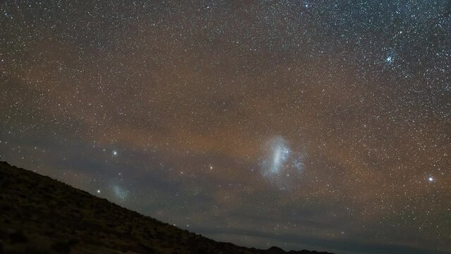Night sky timelapse with tracking taken from Namib desert with Milky Way and Large and Small Magellanic Clouds visible.
