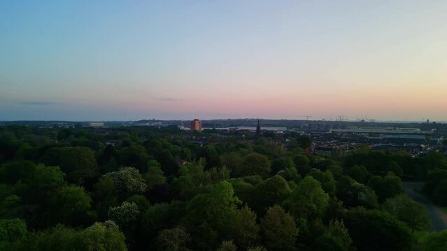 Birkenhead Park, upon which Central Park NY is based - Aerial drone at dawn, rise and pan right, Liverpool skyline yellow sun reveal - May 23