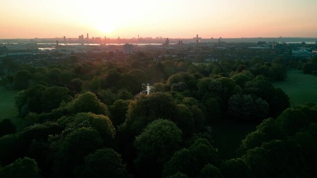 Birkenhead Park, upon which Central Park NY is based - Aerial drone at dawn, Liverpool skyline approach over lake, focus on Grand Entrance - May 23