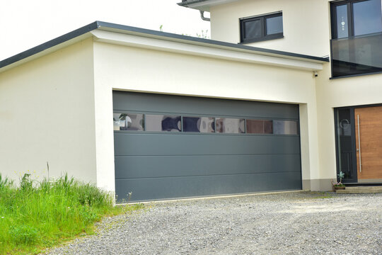 Moderne Beton-Garage mit Automatik-Tor in der Hauszufahrt