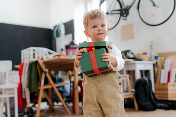 Surprised little boy getting and opening a present.