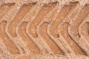 Footprint of car tire tread in a sand gravel road texture. Country road textured background. Backdrop for various ideas. Small stones land. Abstract sandy rough surface. Trendy effect. No people. Tyre