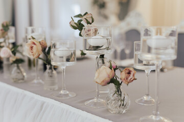 Vases decorated with flowers and candles on the table for holiday.