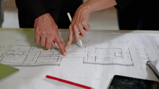 Close up,Entrepreneur and civil engineering team Along with the architect and foreman watching the Blue Print and planning the construction of the building on the construction site.
