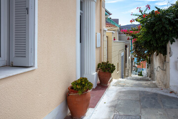 Greece Cyclades. Andros island Chora town. Paved stair house hibiscus bougainvillea pot with plant.